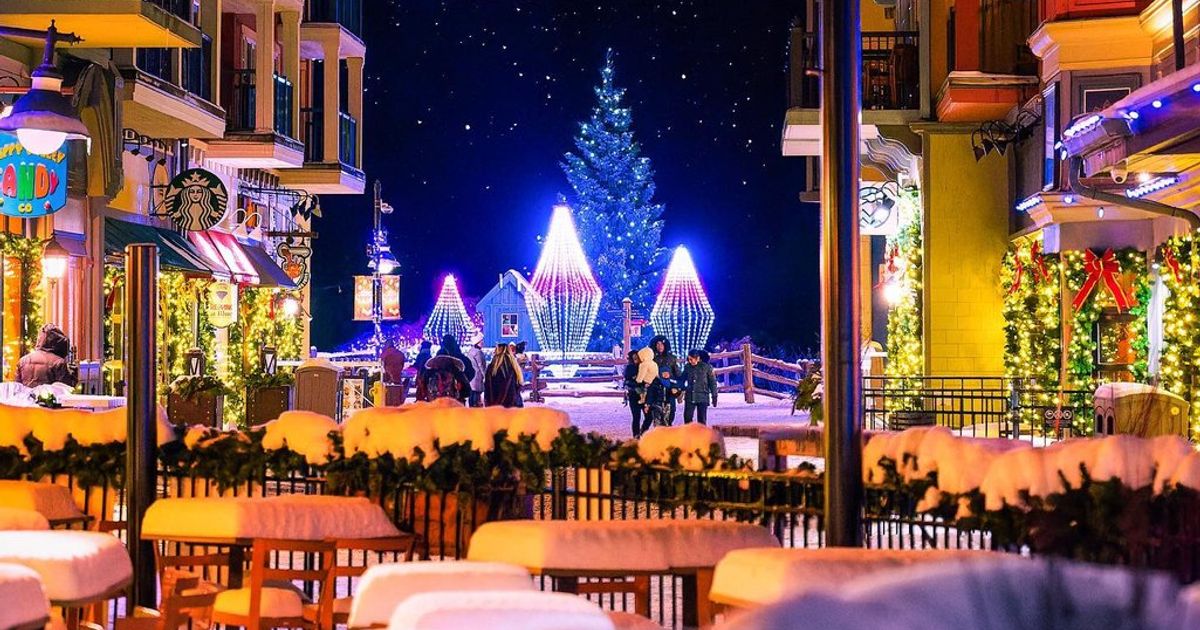 Beauty shot of Main Street in the Village, covered in snow and radiating with festive lights and Holiday decor.