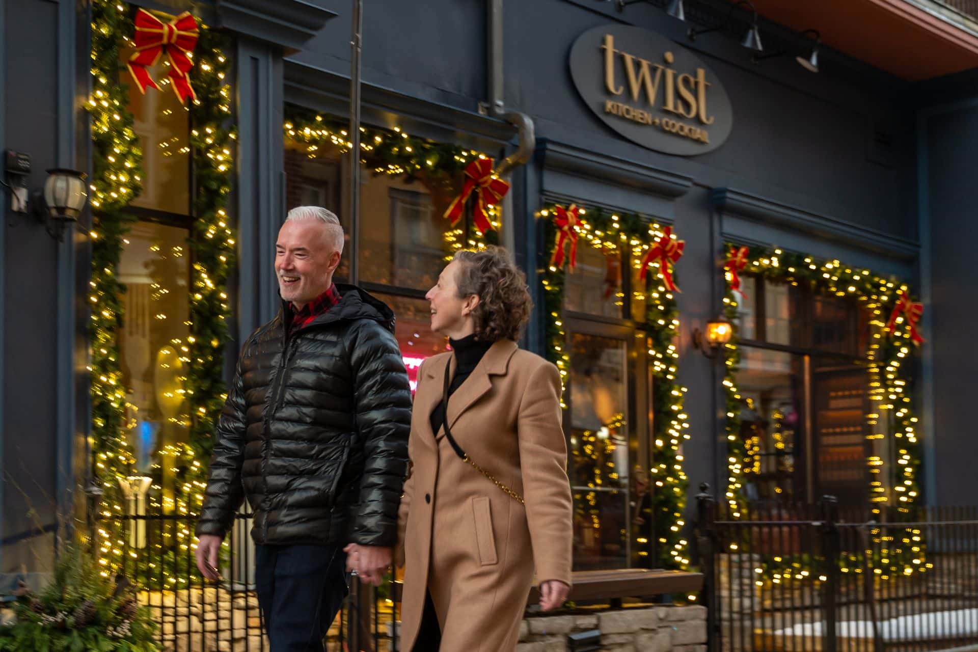 Couple walking through the Holiday Magic Light Trail on their way to dine in the Village.