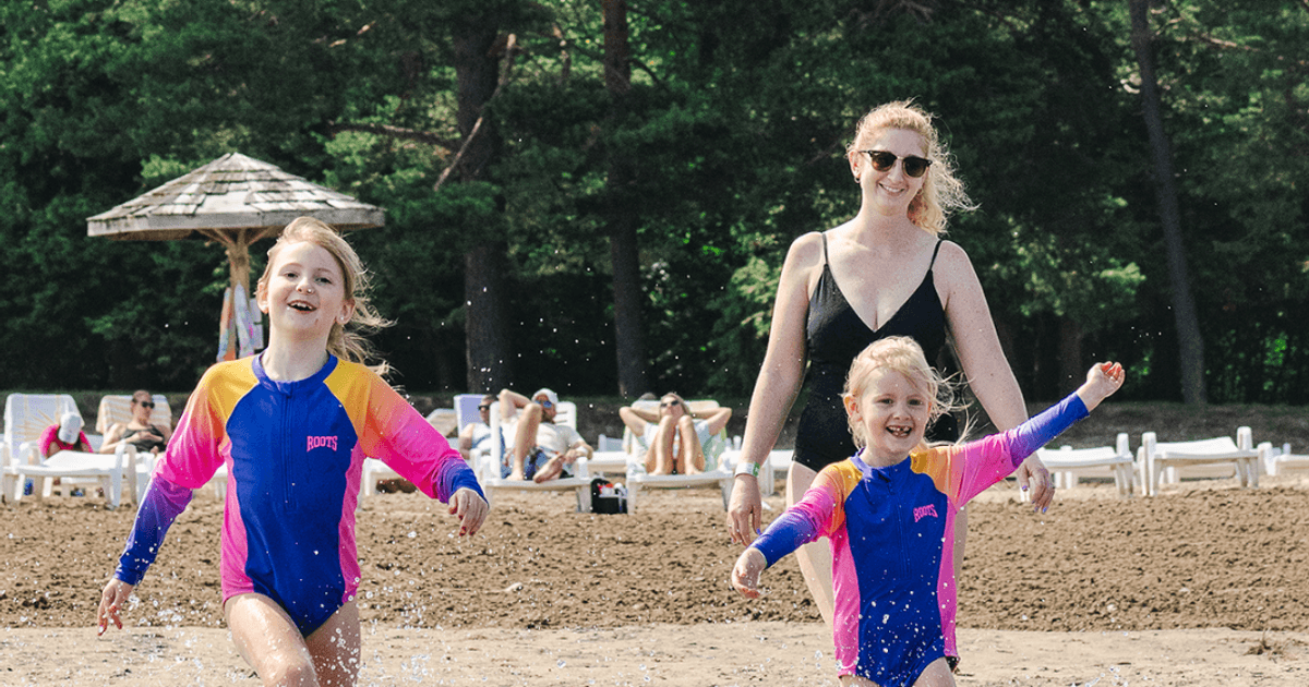 A mom and her two young girls splashing in South Georgian Bay on a Summer day at the Blue Mountain Resort Private Beach.