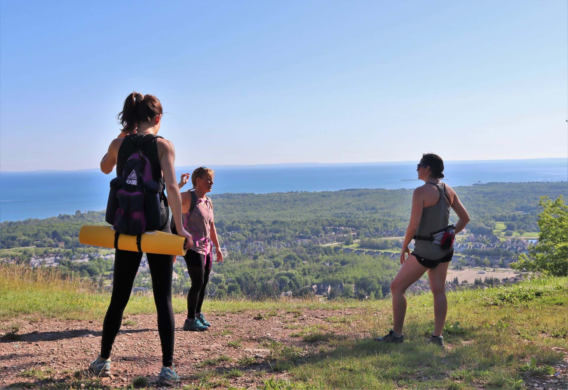 3 friends doing yoga at the top of the mountain.