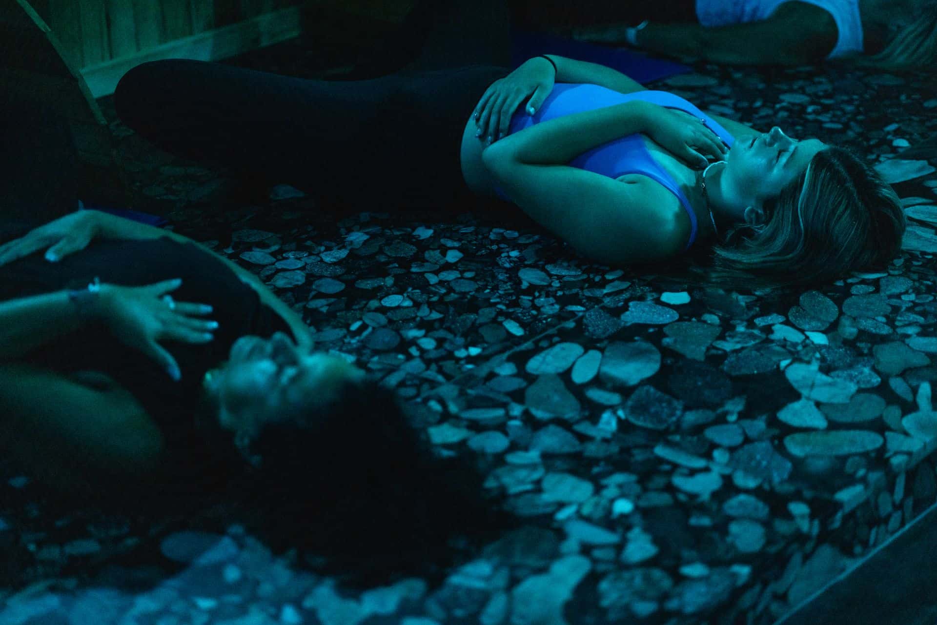 Two women lie down on volcanic rocks at Iwa Spa.