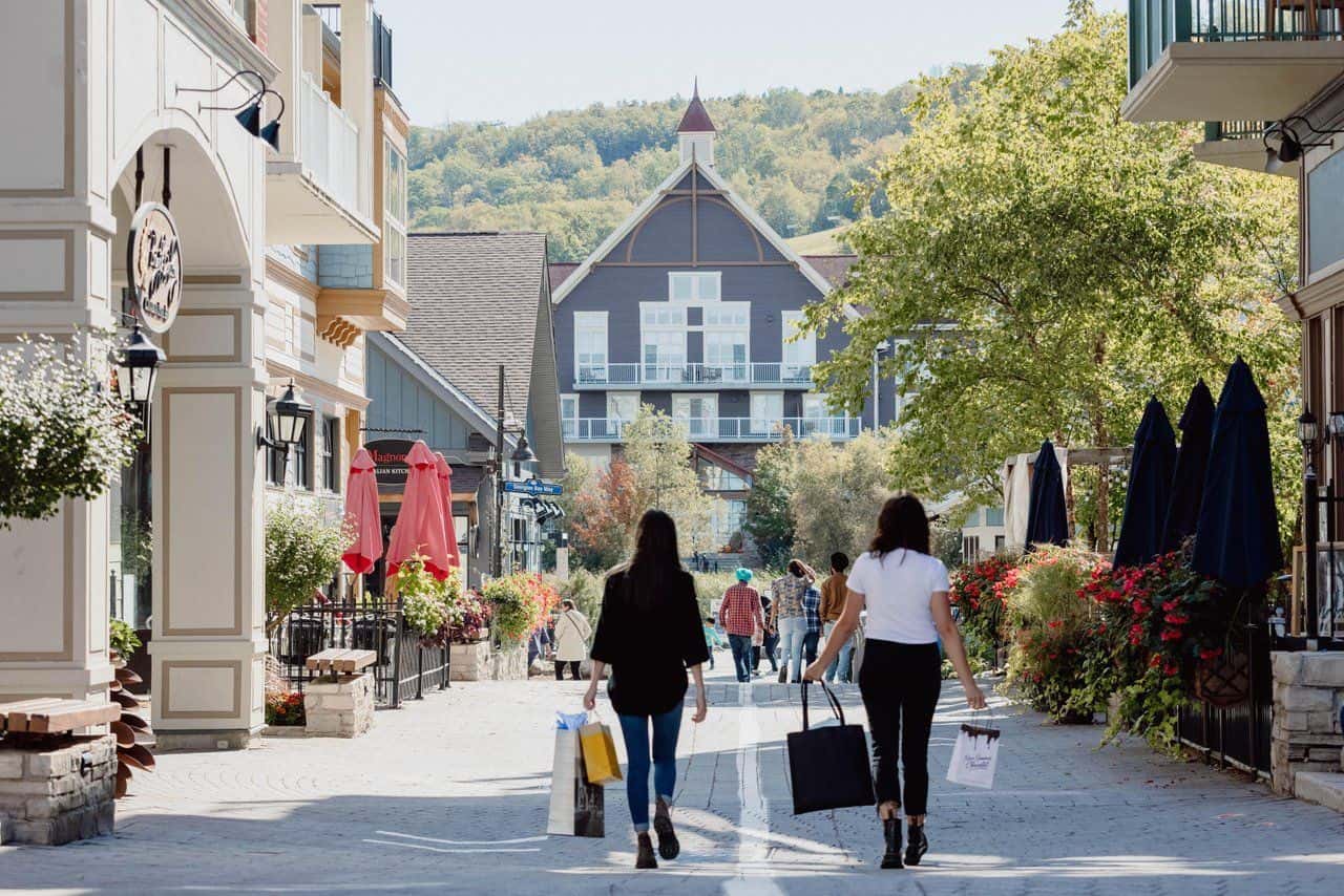 Two ladies shopping in the Village streets in the summer season.