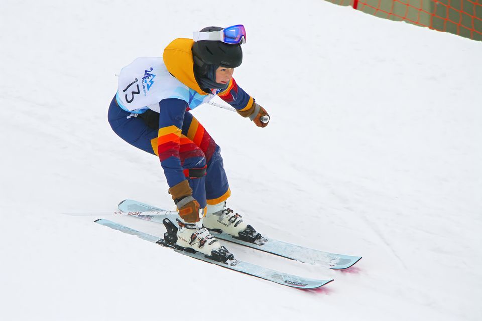 Skier in colorful snowsuit on the slopes, participating in 24h Blue Mountain.