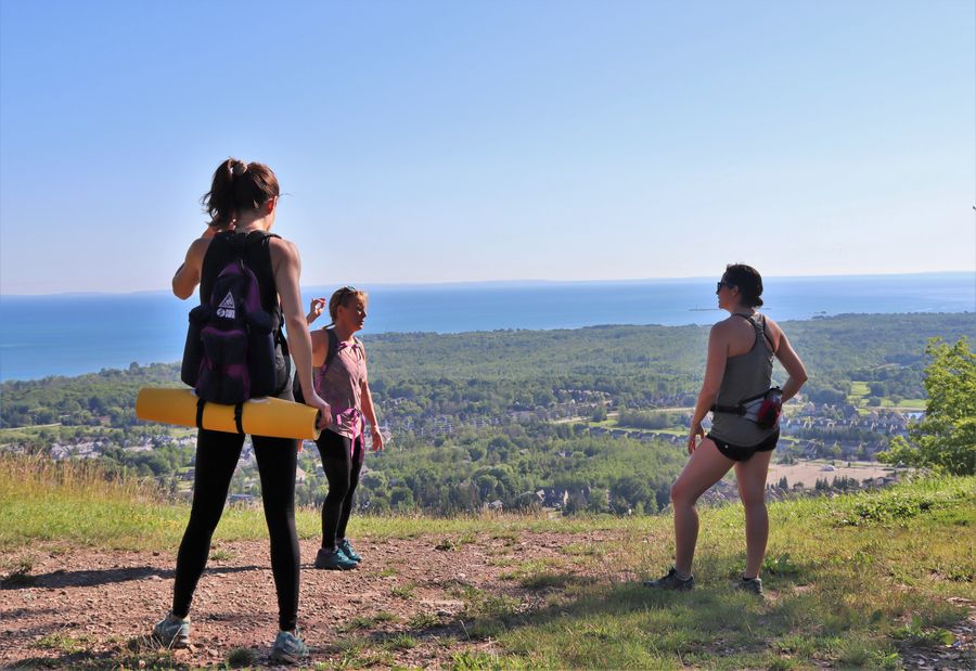 3 friends doing yoga at the top of the mountain.