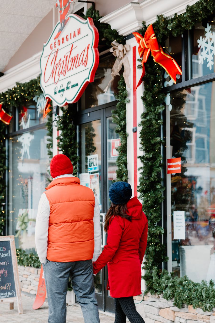 Couple strolling by the Georgian Christmas Store in the Village during the daytime of Holiday Magic.