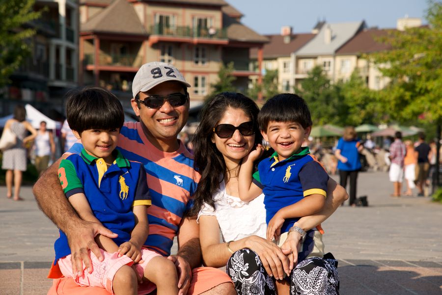 A family of four smiling for a photo in the events plaza.