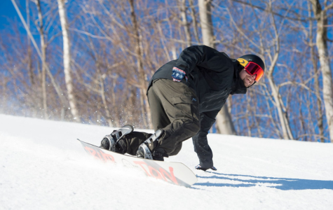 Man snowboarding down fresh powder on the Mountain