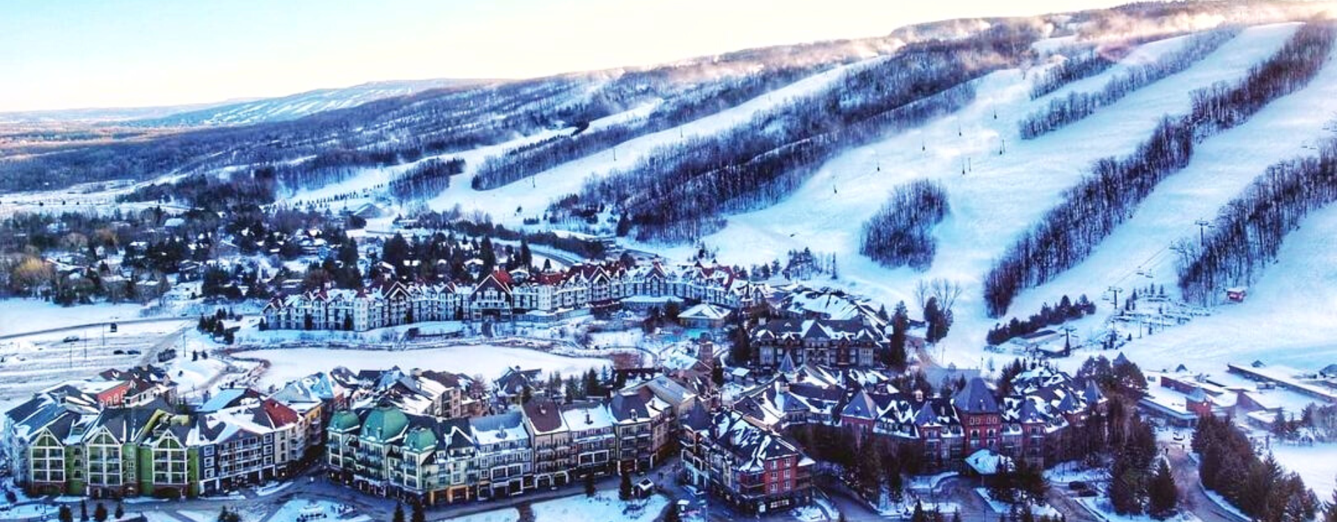 A stunning birds-eye view of the Village and Mountain landscape covered in a blanket of fresh snow.